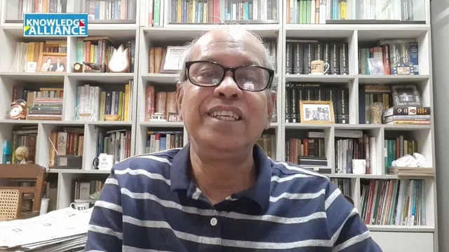 Khondokar Shakhawat Ali smiling in his book-lined study during a Knowledge Alliance recording