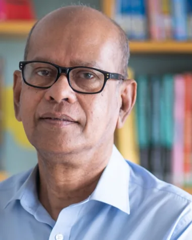Portrait, wearing glasses, in front of a bookshelf